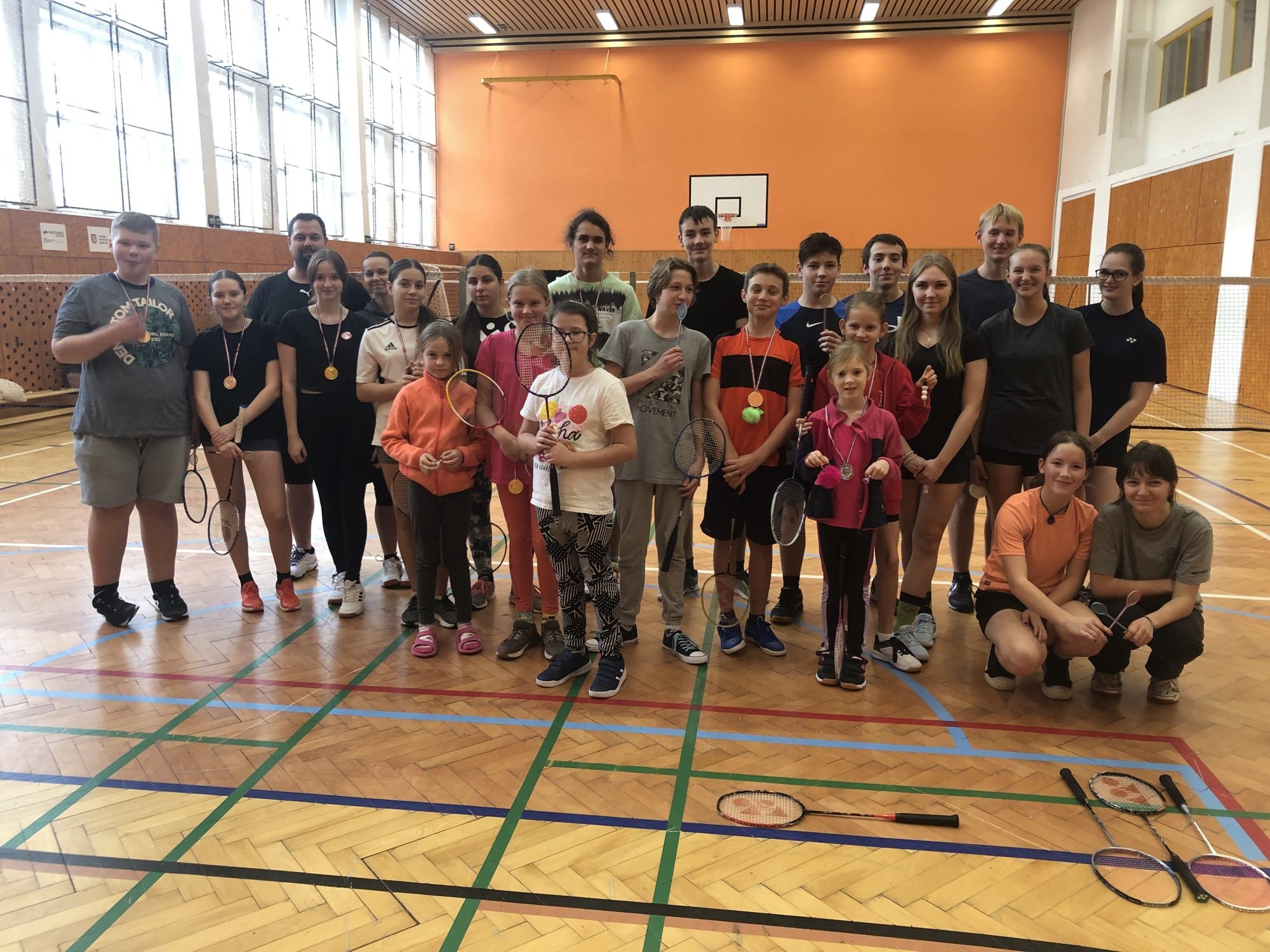 Děti a trenéři badmintonového oddílu v tělocvičně